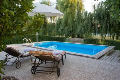 a swimming pool with two chairs and an umbrella at Apartment Šilec in Šmarje pri Jelšah