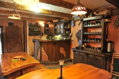a restaurant with two tables and a bar with wine bottles at Apartment Šilec in Šmarje pri Jelšah
