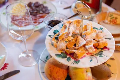 a plate of food on a table with a glass of wine at Turistična kmetija Vrezner Apartment in Zgornja Kungota