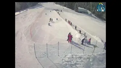 a group of people skiing down a snow covered slope at Apartmaji Koželj in Ribnica na Pohorju