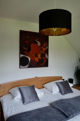a bedroom with a bed with a painting on the wall at Rudi Hiti's Guest House in Bled