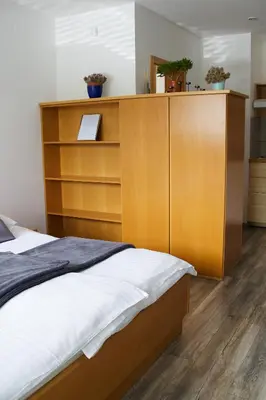 a bedroom with a bed and a wooden cabinet at Rudi Hiti's Guest House in Bled