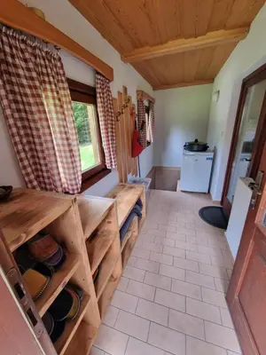 a room with wooden shelves and a kitchen with a window at Lodge In Koprivnik in Koprivnik v Bohinju