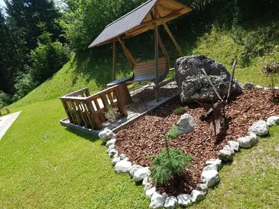 a garden with a wooden bench and a gazebo at Lodge In Koprivnik in Koprivnik v Bohinju