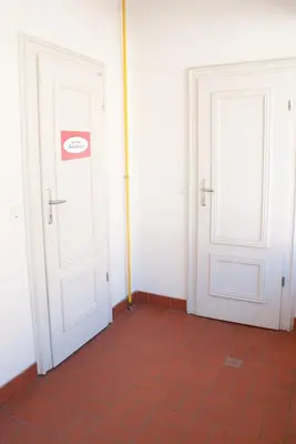 two white doors in a room with a red tile floor at Apartment Bon Voyage in Maribor