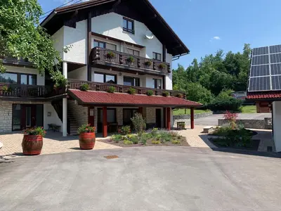 a building with potted plants in front of it at Žigon Bed & Breakfast in Logatec