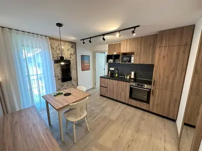 a kitchen with a wooden table and a dining room at Žigon Bed & Breakfast in Logatec