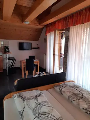 a bedroom with a bed and a dining room with a table at Haus Alexandra Apartment in Bled