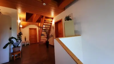 a room with a white wall and a stair case at Haus Alexandra Apartment in Bled