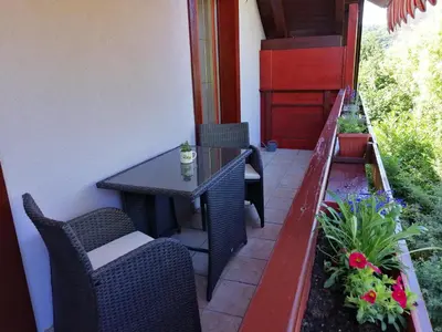 a patio with a table and chairs on a balcony at Haus Alexandra Apartment in Bled