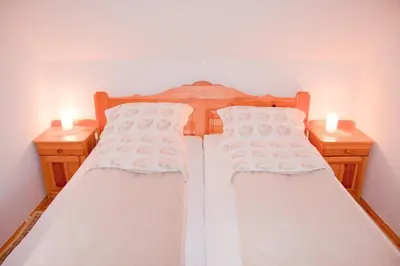 a bedroom with two beds and two candles on two tables at Farm stay Bukovje in Ljubno