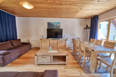 a living room with a couch and a table at Jacobs Resort House Kranjska Gora in Kranjska Gora