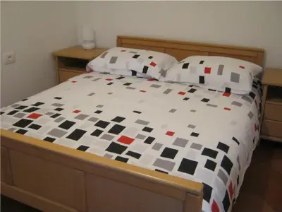 a bed with a checkered comforter and two pillows at House Dolenja Trebuša in Dolenja Trebuša