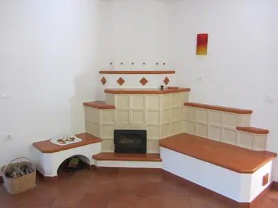 a living room with a fireplace and a stove at House Dolenja Trebuša in Dolenja Trebuša