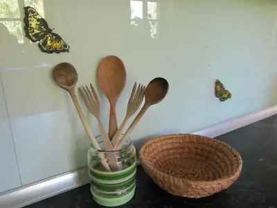 a glass jar filled with wooden spoons and a basket at House Dolenja Trebuša in Dolenja Trebuša
