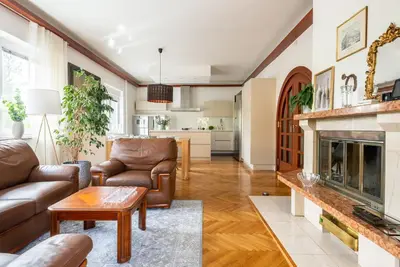 a living room with leather furniture and a fireplace at Vila Tivoli in Ljubljana
