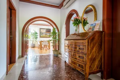 a hallway with a wooden dresser and two mirrors at Vila Tivoli in Ljubljana