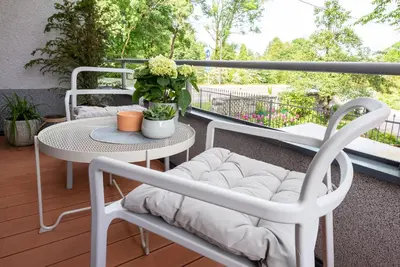 a patio with a table and chairs on a balcony at Vila Tivoli in Ljubljana