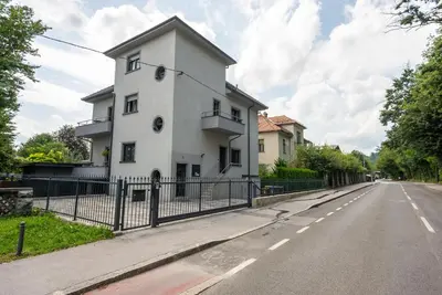 a white building on the side of a road at Vila Tivoli in Ljubljana