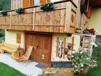 a small house with a deck and a bench at Počitniška hiška Kašta in Luče