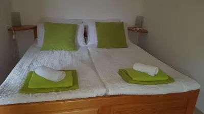 a bed with green and white pillows on it at Apartments Tatjana in Bovec