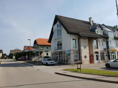 a street in a town with cars parked on the road at Soncnica Apartment in Moravske Toplice