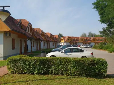 a white car parked in front of a row of houses at Soncnica Apartment in Moravske Toplice