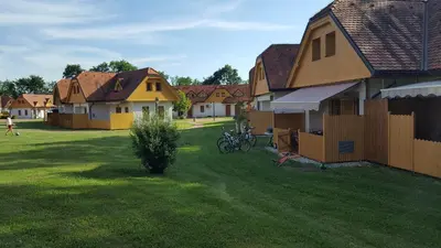 a group of houses in a yard next to a house at Soncnica Apartment in Moravske Toplice
