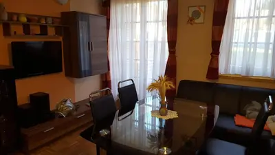 a living room with a glass table and a couch at Soncnica Apartment in Moravske Toplice