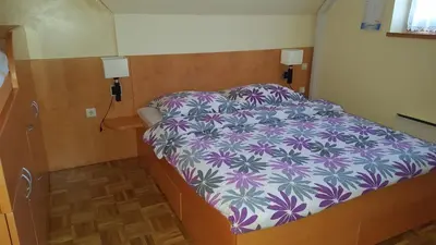 a bedroom with a bed with a purple and white comforter at Soncnica Apartment in Moravske Toplice