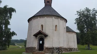 a building with a tower with a bike parked next to it at Soncnica Apartment in Moravske Toplice