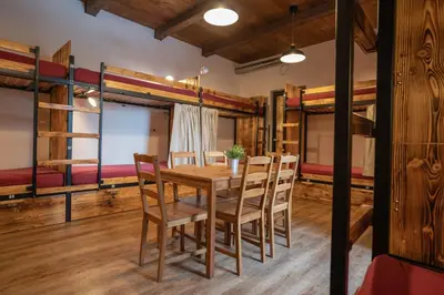 a dining room with a table and chairs and bunk beds at Turn Hostel in Ljubljana