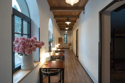 a row of tables in a hallway with flowers at Turn Hostel in Ljubljana