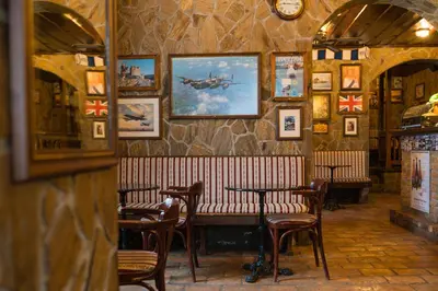 a restaurant with a bench and tables and pictures on the wall at Turn Hostel in Ljubljana