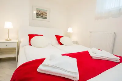 a bedroom with two beds with red and white towels at Apartments Grom in Bled
