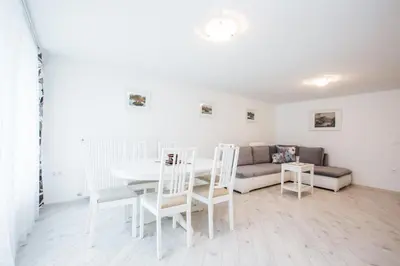 a living room with a table and chairs and a couch at Apartments Grom in Bled