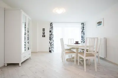 a white dining room with a table and chairs at Apartments Grom in Bled