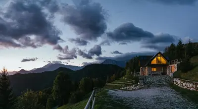 a house on the side of a hill with a mountain at Eco Chalet Astra Montana in Tolmin