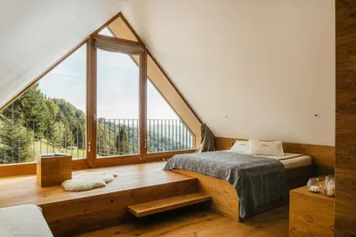 a bedroom with a bed and a large window at Eco Chalet Astra Montana in Tolmin