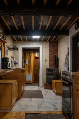 a large kitchen with wooden cabinets and a stove at Počitniška hiša Koča Dobnik in Lovrenc na Pohorju