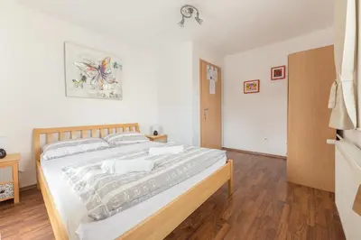 a bedroom with a large bed with white sheets at Hostel Mama Minka in Bohinj