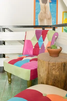 a colorful chair sitting next to a wooden table at Hostel Mama Minka in Bohinj
