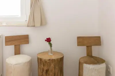 a flower in a vase sitting on two wooden stools at Hostel Mama Minka in Bohinj