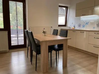 a kitchen with a wooden table and black chairs at Apartment Vrtacnik in Štefanja Gora