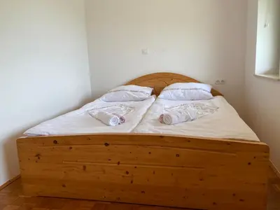 a bedroom with a wooden bed with two pillows at Apartment Vrtacnik in Štefanja Gora