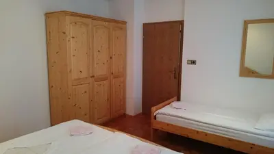a small room with two beds and a mirror at Apartment Vrtacnik in Štefanja Gora