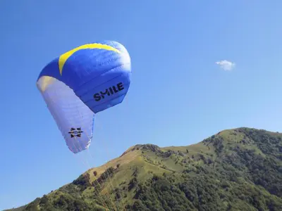 a blue and white parachute flying over a mountain at Apartment Pri Ruscu in Tolmin