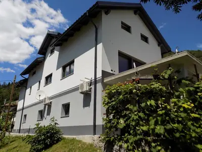 a white building with a black roof at Apartment Pri Ruscu in Tolmin