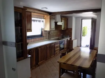 a kitchen with a wooden table and a dining room at Apartment Pri Ruscu in Tolmin