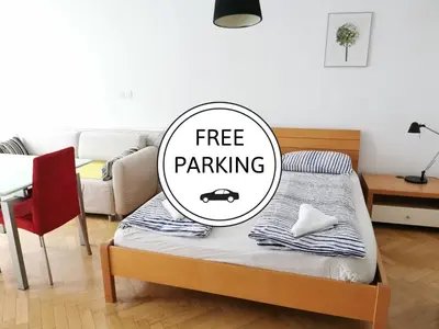 a bed with a free parking sign on it in a living room at City centre studio with a balcony and free parking in Ljubljana